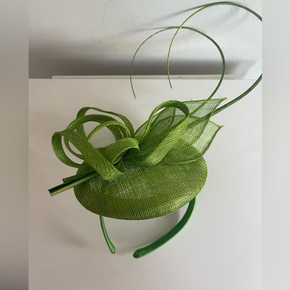 Green fascinator with feather detailing.